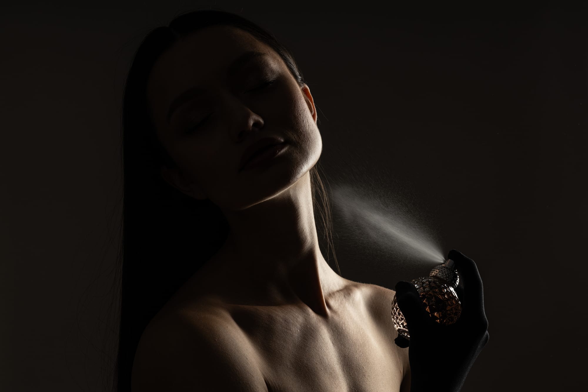Young woman applying pheromone perfume